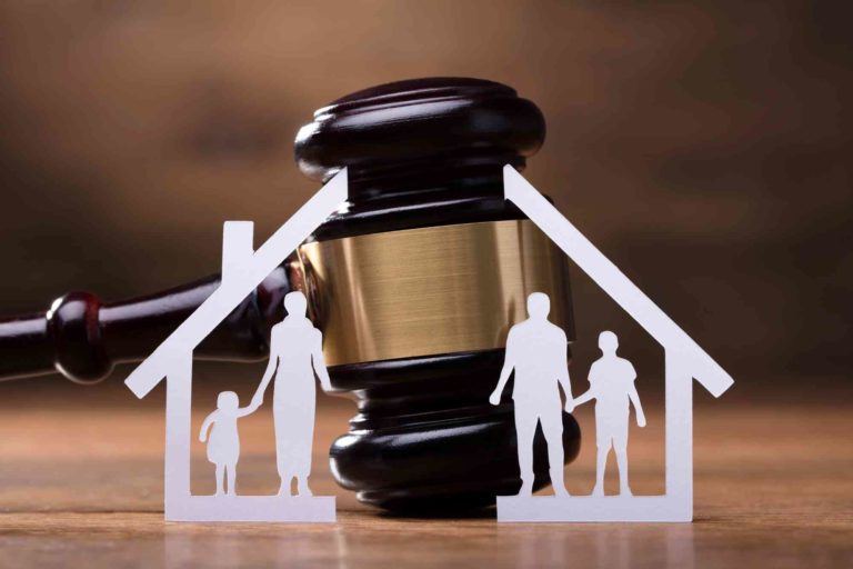 Richterhammer hinter getrenntem Haus und getrennter Familie aus Papier