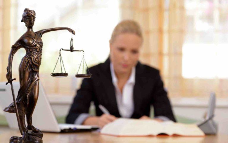 Junge Anwältin sitzt am Schreibtisch