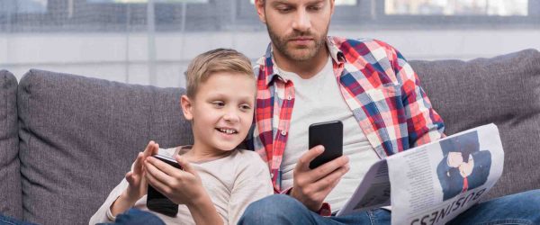Vater und Sohn spielen am Smartphone